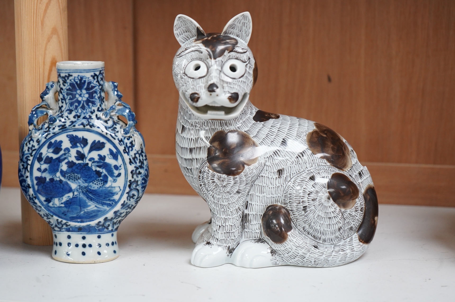 A 19th century Chinese blue and white small moon flask together with a later jar and a Portugese porcelain copy of a Chinese export cat, largest 19cm high